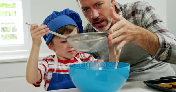 Father helping boy to filter flour using a strainer — Stock Video