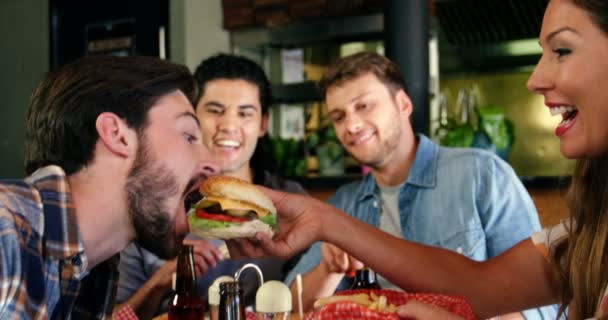 Mujer alimentando hamburguesa al hombre — Vídeos de Stock