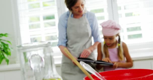 Mother and daughter looking recipe book — Stock Video