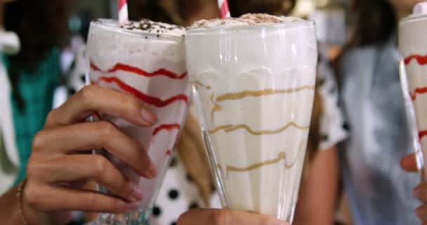 Lachende vriendinnen roosteren glas smoothie — Stockvideo