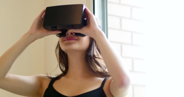 Улыбающаяся женщина с помощью гарнитуры виртуальной реальности — стоковое видео