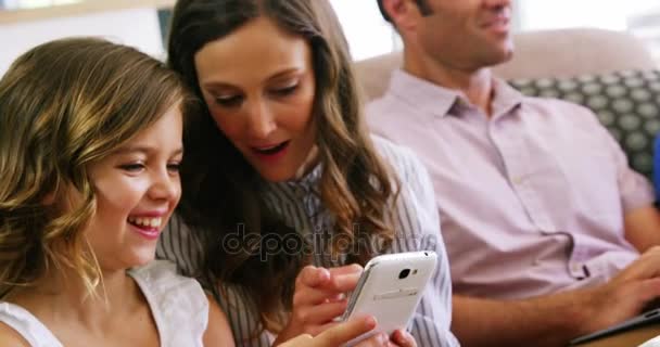 Madre e hija usando teléfono móvil en la sala de estar — Vídeos de Stock