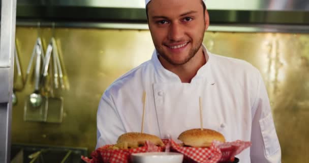 Gelukkig chef-kok presenteert voedsel in keuken — Stockvideo