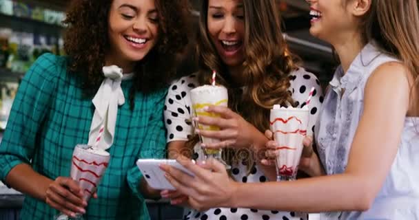 Amigos femeninos mirando el teléfono móvil — Vídeo de stock