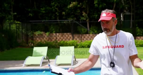 Lifeguard segurando prancheta e assobiando — Vídeo de Stock