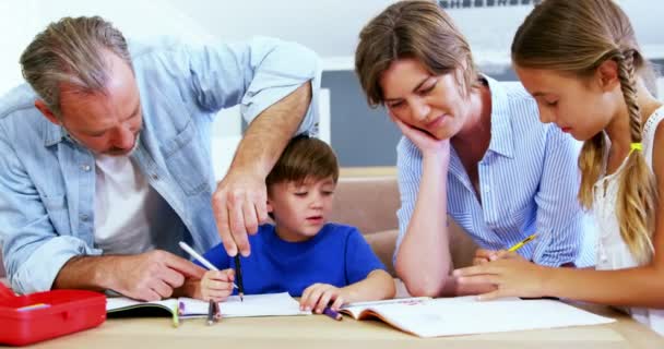Vater und Mutter helfen Kindern bei den Hausaufgaben — Stockvideo