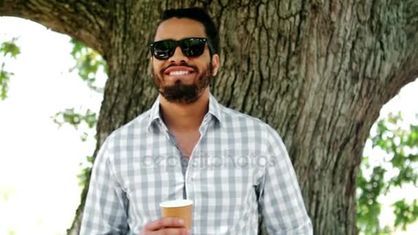 Homme souriant portant des lunettes de soleil tenant un verre de champagne — Video