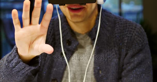 Человек с помощью гарнитуры виртуальной реальности дома — стоковое видео