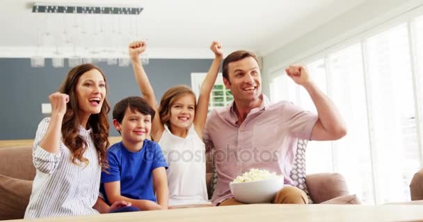 Glückliche Familie vor dem Fernseher im Wohnzimmer — Stockvideo