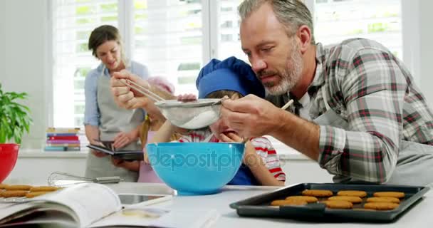 Father helping boy to filter flour using a strainer — Stock Video