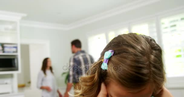 Ragazza coprendo le orecchie mentre i genitori litigano in background — Video Stock