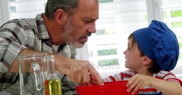 Père et garçon mélangeant la pâte dans un bol — Video