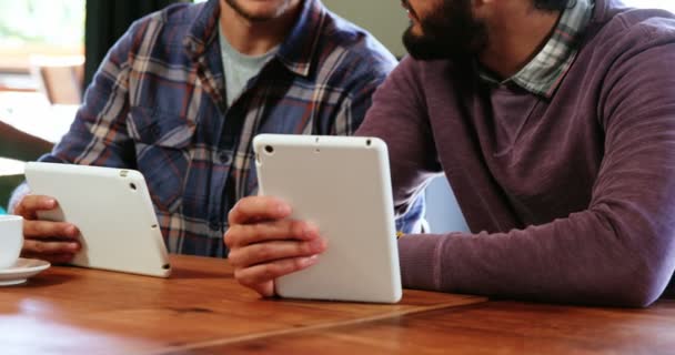 Amigos usando tablet digital e interagindo uns com os outros — Vídeo de Stock