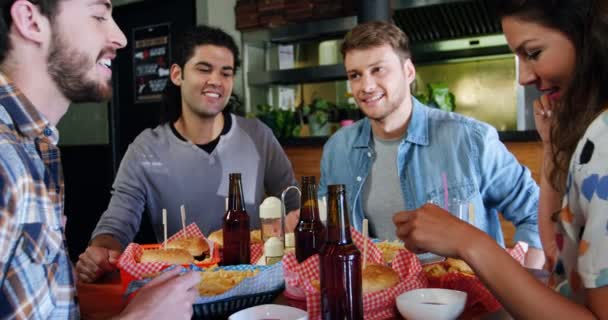 Друзі мають бургер в ресторані — стокове відео