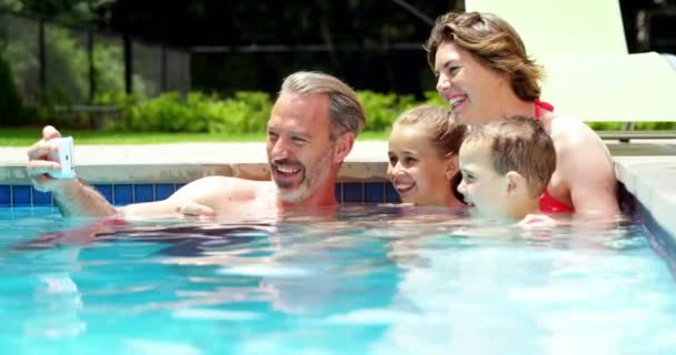 Familia tomando un selfie en el teléfono móvil en la piscina — Vídeo de stock