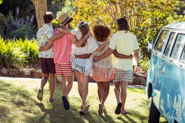 Rear view of friends standing together with arms around — Stock Photo, Image