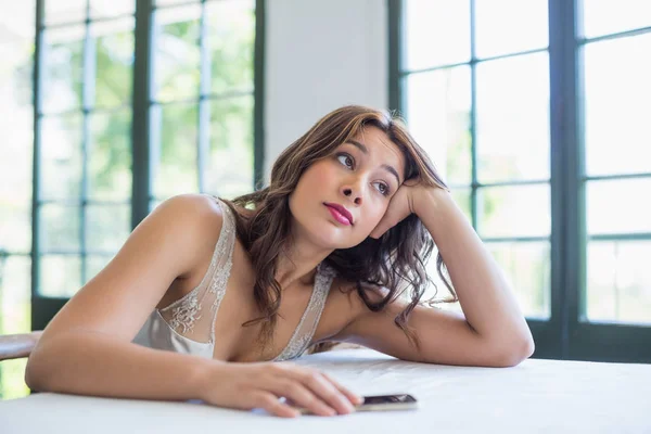 Mulher bonita com telefone celular descansando em seu cotovelo — Fotografia de Stock