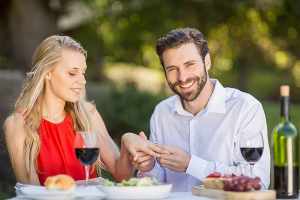 Hombre poniendo un anillo en el dedo de las mujeres en el restaurante — Foto de Stock