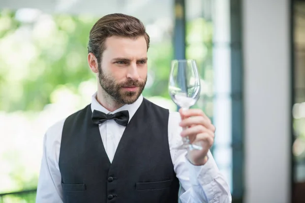 Mužské číšník drží sklenka na víno v restauraci — Stock fotografie