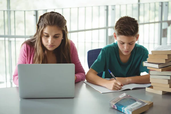 Schulkinder machen Hausaufgaben in der Bibliothek — Stockfoto