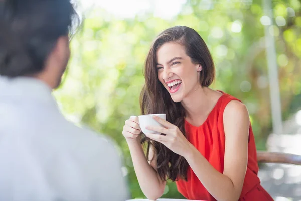 Mulher bonita rindo enquanto toma café — Fotografia de Stock