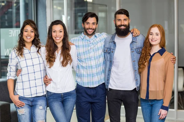 Retrato de ejecutivos masculinos y femeninos de pie con brazos alrededor — Foto de Stock