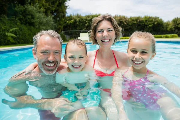 Šťastní rodiče a děti v bazénu — Stock fotografie