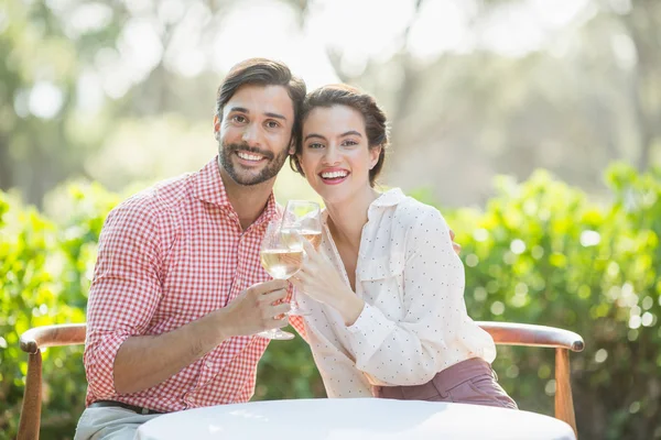 Casal brindar copos de vinho enquanto sentado no restaurante — Fotografia de Stock