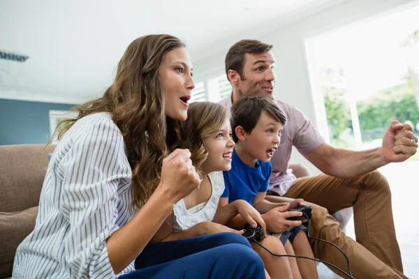 Aufgeregte Familie spielt gemeinsam Videospiele — Stockfoto