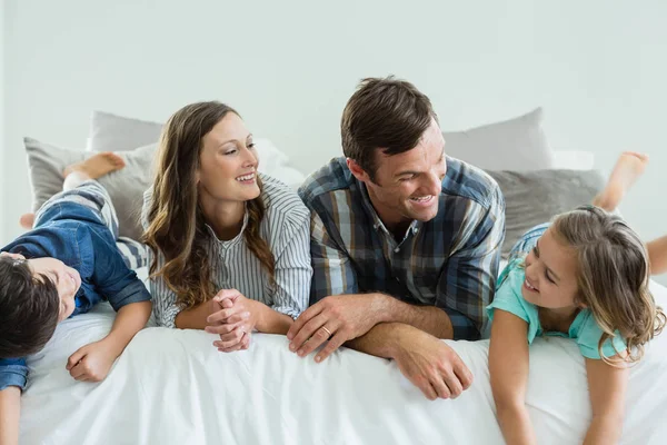 Famille jouant au lit dans la chambre à coucher à la maison — Photo