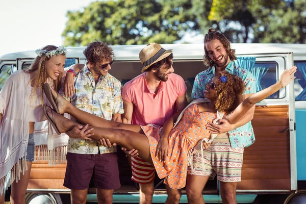 Group of friends lifting woman near campervan — Stock Photo, Image