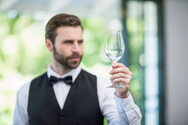 Male waiter holding wine glass in the restaurant — Stock Photo, Image