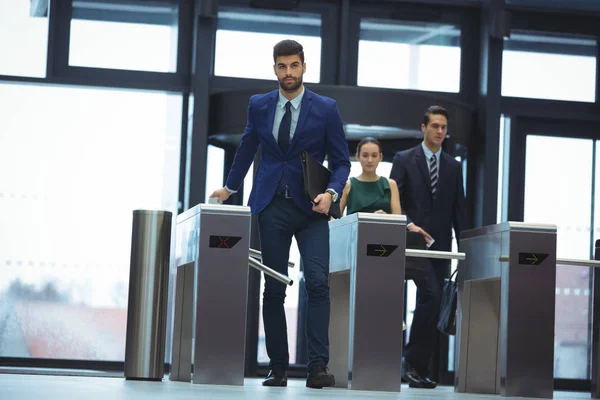 Businessman passing through turnstile gate — Stock Photo, Image