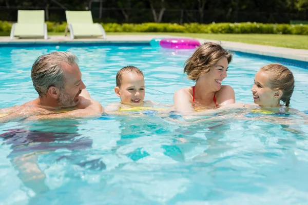 Pais e filhos se divertindo na beira da piscina — Fotografia de Stock