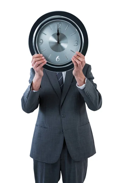 Homme d'affaires tenant une horloge devant son visage — Photo