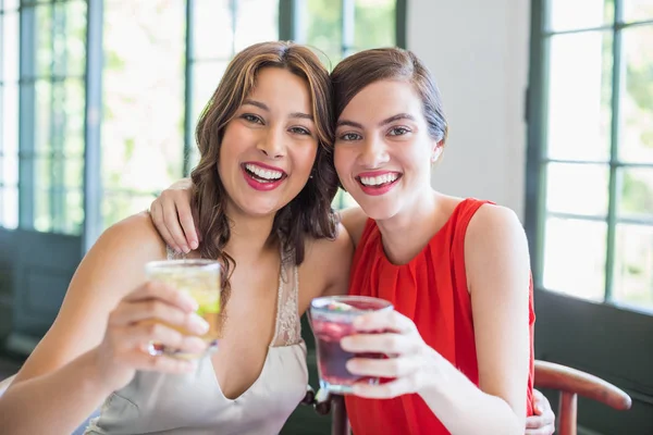 Happy friends hugging each other while holding cocktail glasses — Stock Photo, Image