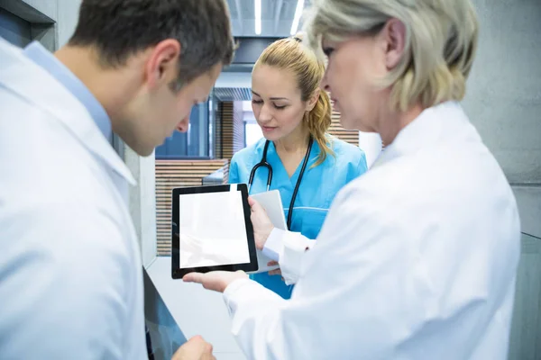 Medical team discussing over digital tablet — Stock Photo, Image