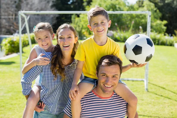 Arents carrying their two children on shoulders — Stock Photo, Image