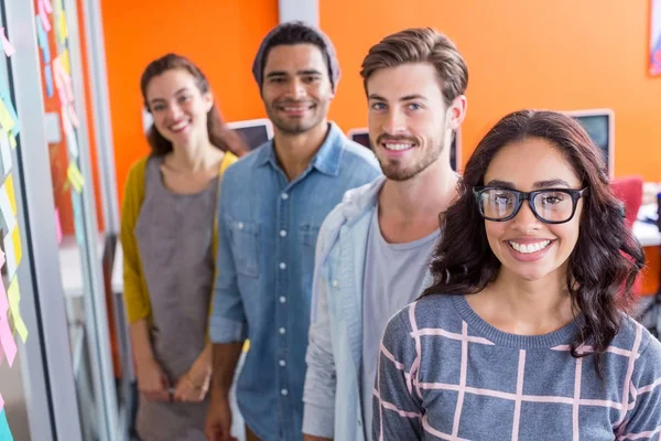Portrait of smiling executives standing in a row — Stock Photo, Image