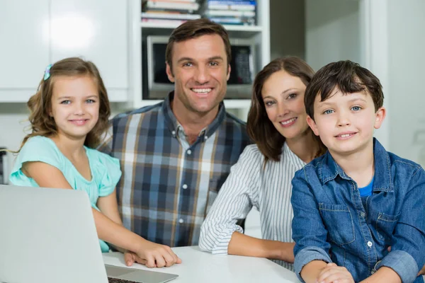 Lächelnde Familie mit Laptop im Wohnzimmer — Stockfoto
