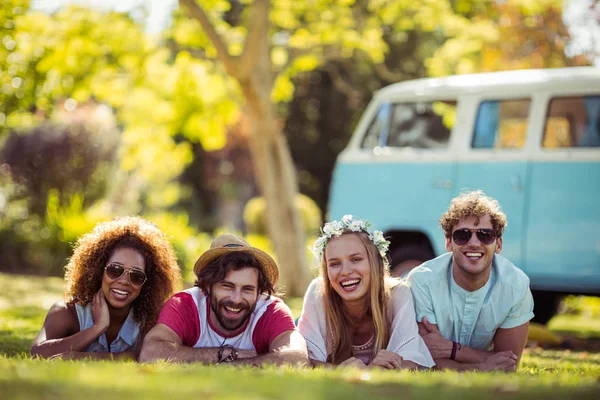 Portrait of happy friends lying on grass together — Stock Photo, Image