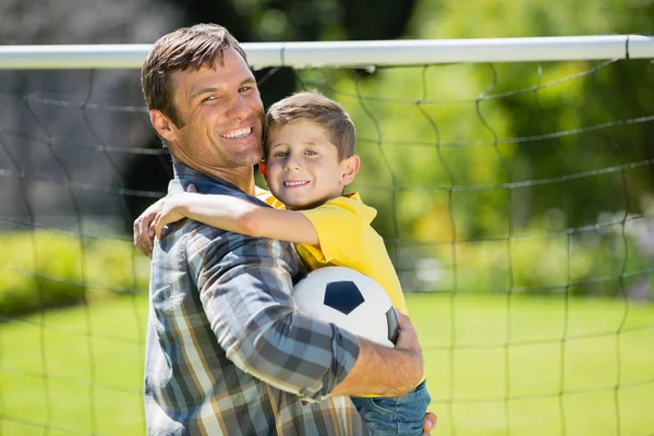 Pai e filho com futebol no parque — Fotografia de Stock