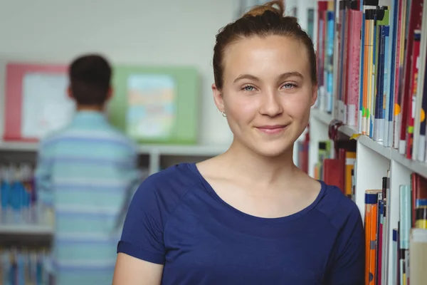Portret van glimlachen schoolmeisje glimlachend in bibliotheek — Stockfoto