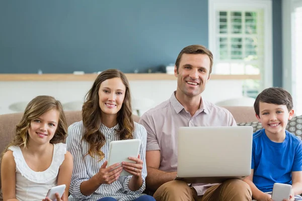 Famille utilisant tablette, téléphone et ordinateur portable — Photo