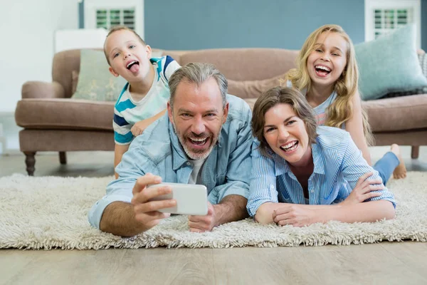 Famiglia prendendo selfie mentre sdraiati insieme — Foto Stock