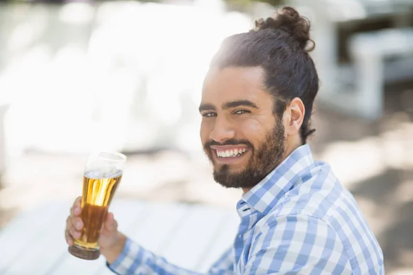 Man holding beer glass in the park on a sunny day — Stock Photo, Image