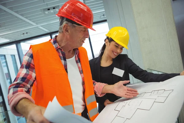 Businesswoman discussing over blueprint with architect — Stock Photo, Image