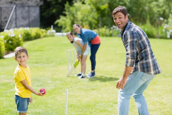 Família feliz jogando críquete juntos — Fotografia de Stock