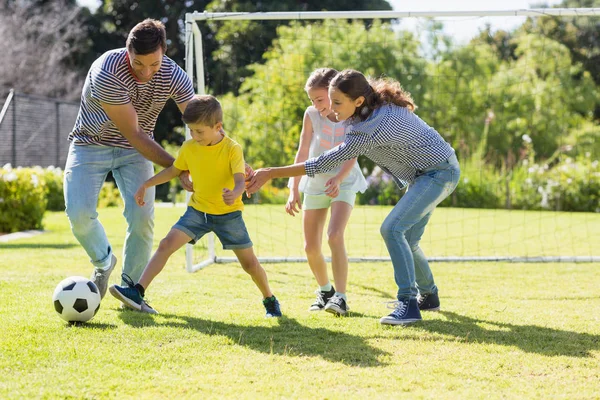 Family playing football together at the park — Stock Photo, Image