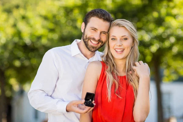 Pareja feliz sosteniendo anillo de pie en el restaurante —  Fotos de Stock